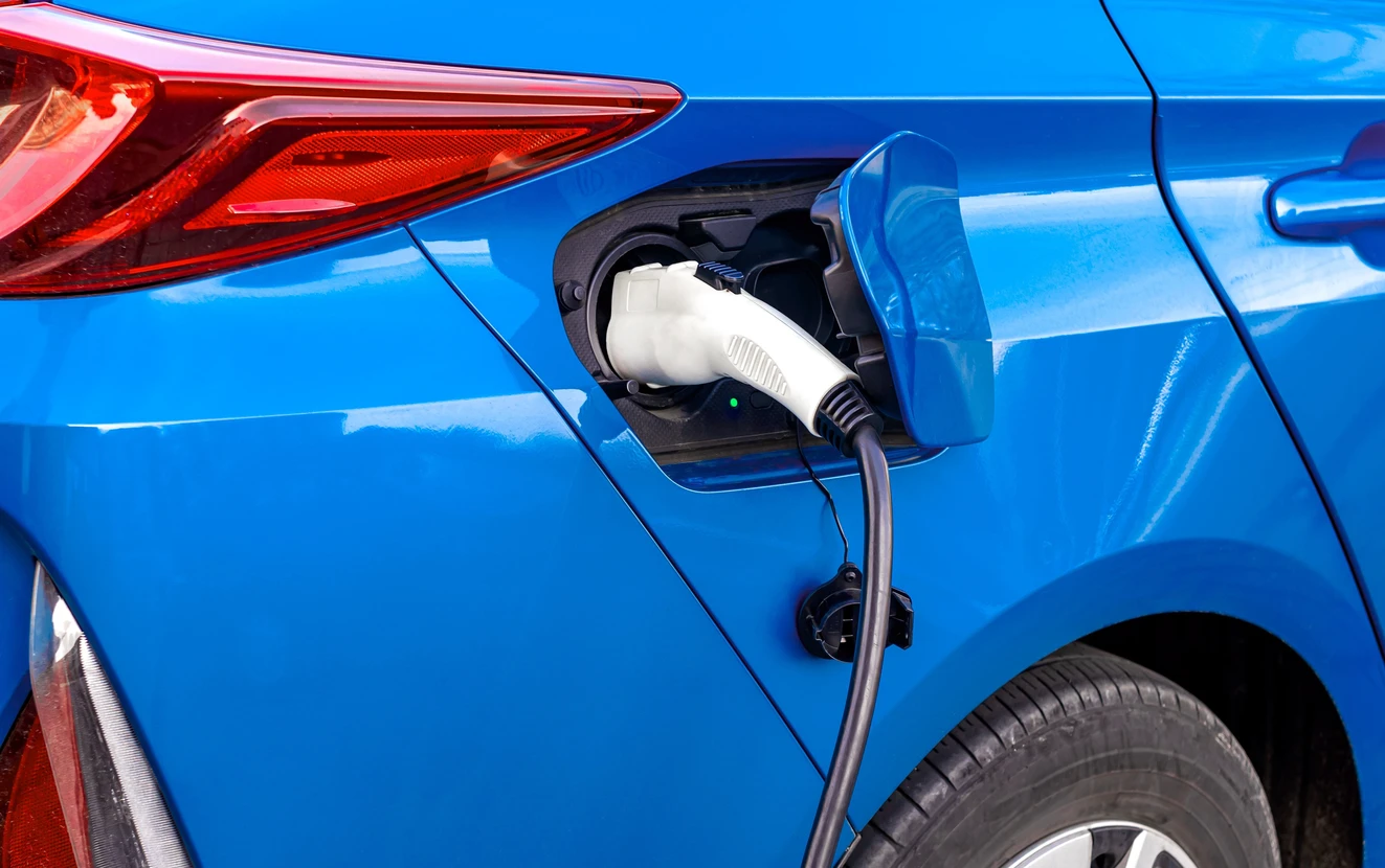 Véhicule électrique bleu en cours de recharge sur voie publique