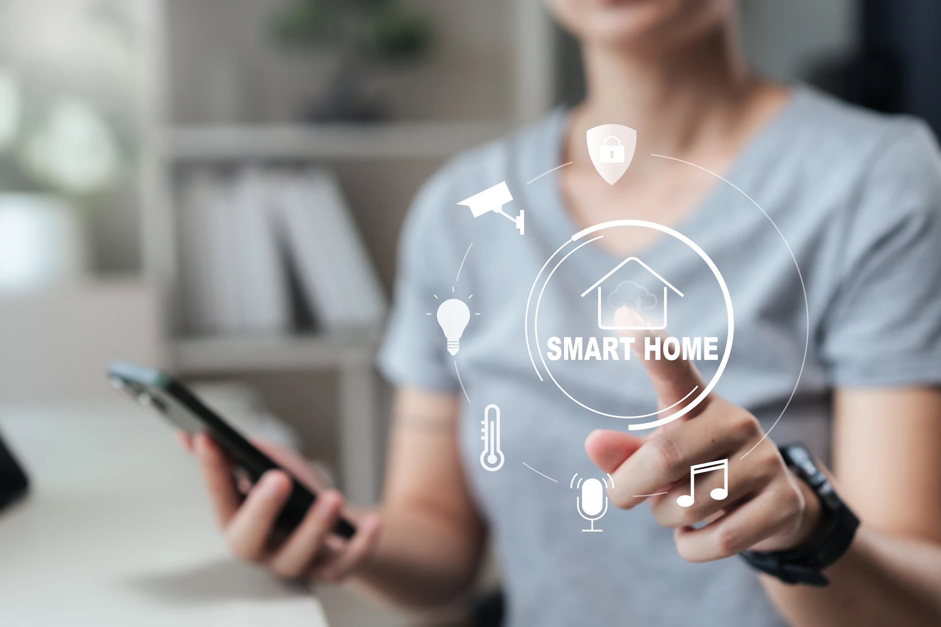 Homme tenant un smartphone avec une maison miniature flottant au-dessus, entouré d'icônes de domotique (sécurité, caméra, thermomètre, ampoule, musique)